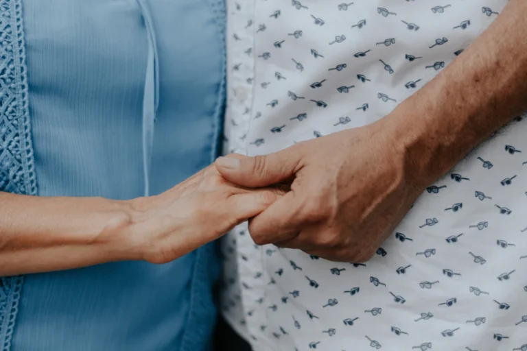 Duas pessoas de mãos dadas, gesto de cuidado